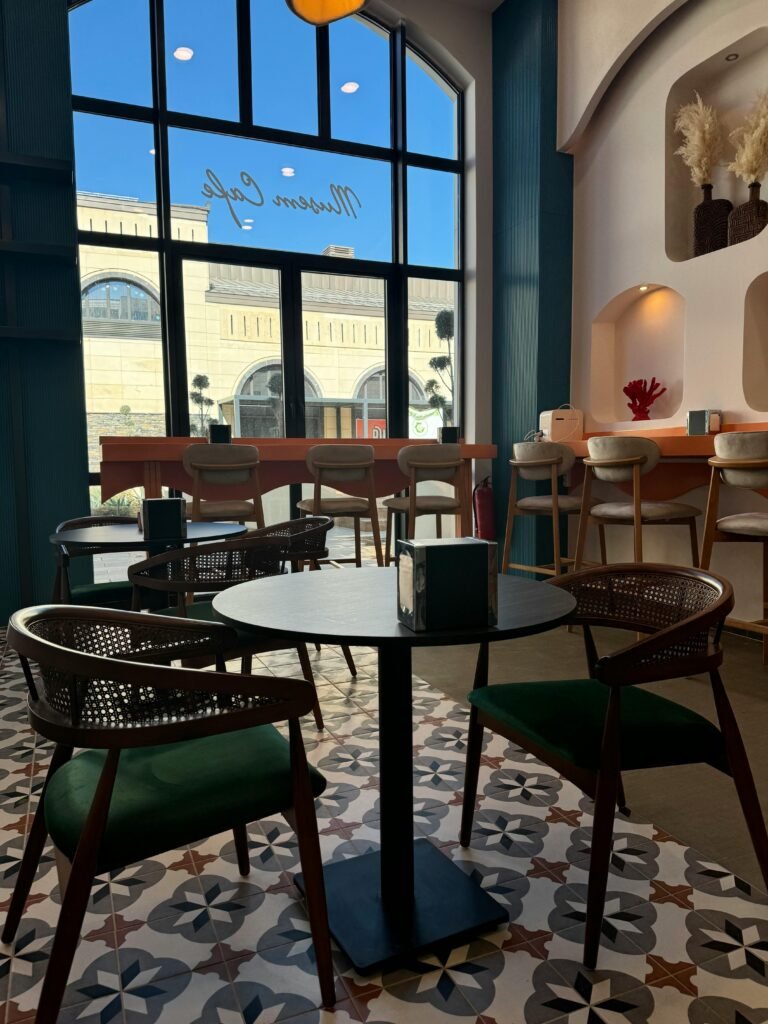 A stylish, modern cafe interior with elegant chairs and large windows, creating a cozy atmosphere.